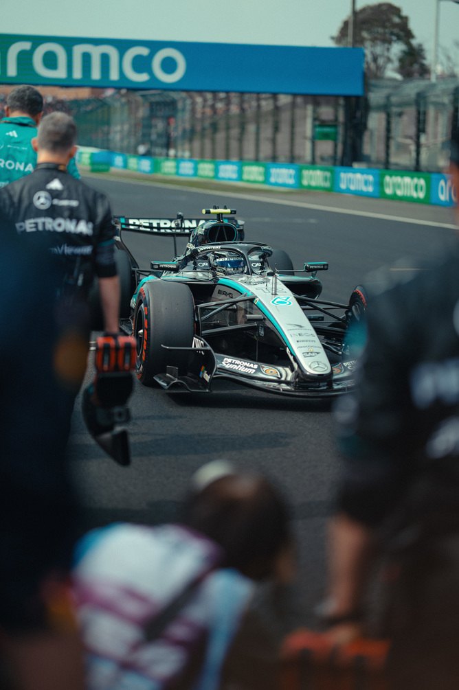 Mercedes F1-bil i pitlane omgivet af teamet
