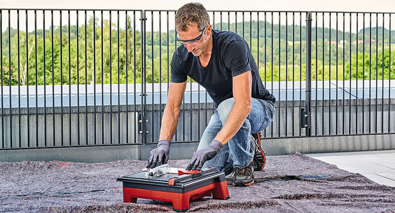 man using a cordless tile cutting machine